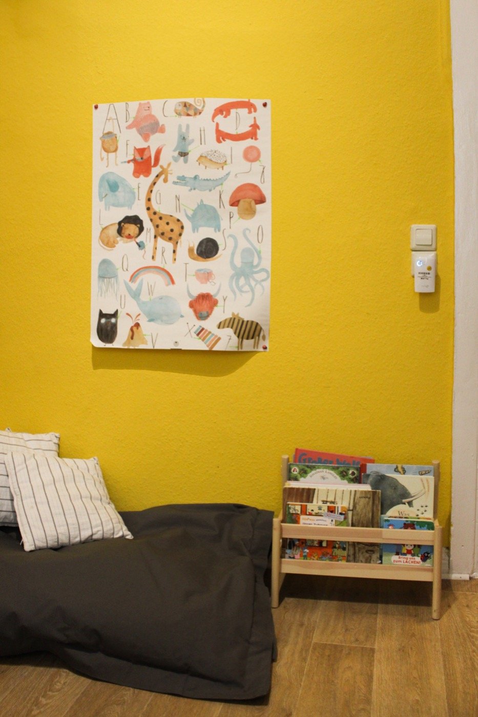 Gelbe Wand mit Tierposter, Matratze und Bücherregal